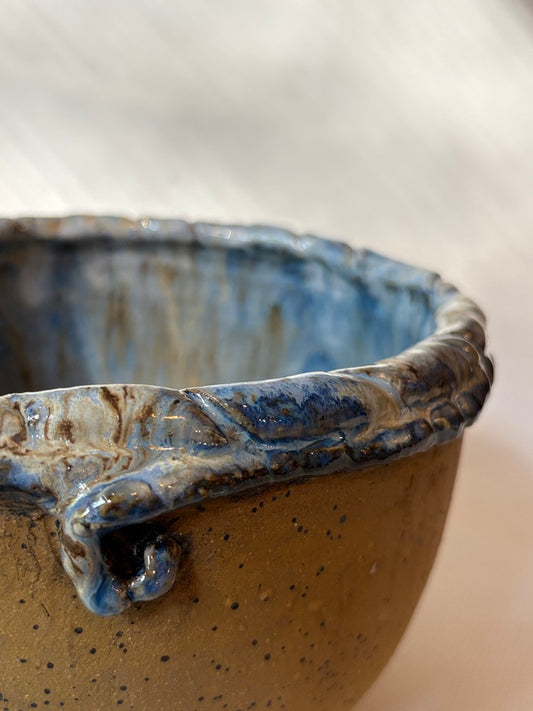 Light blue handmade placenta bowl with a cluster of sculpted flowers on the rim