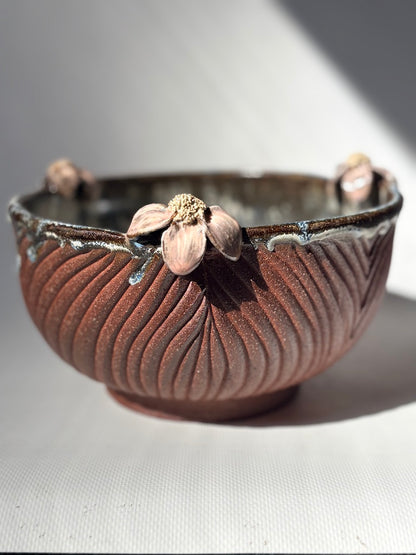 Brown ribbed handmade placenta bowl with a sculpted flower on the rim