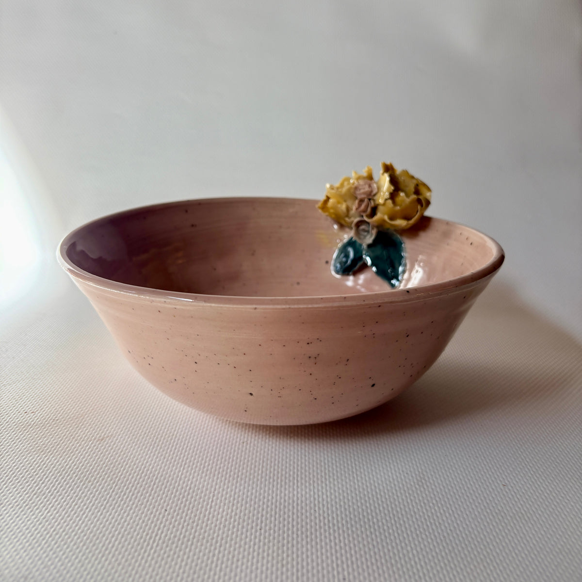 Close up of floral accent on pink celadon bowl
