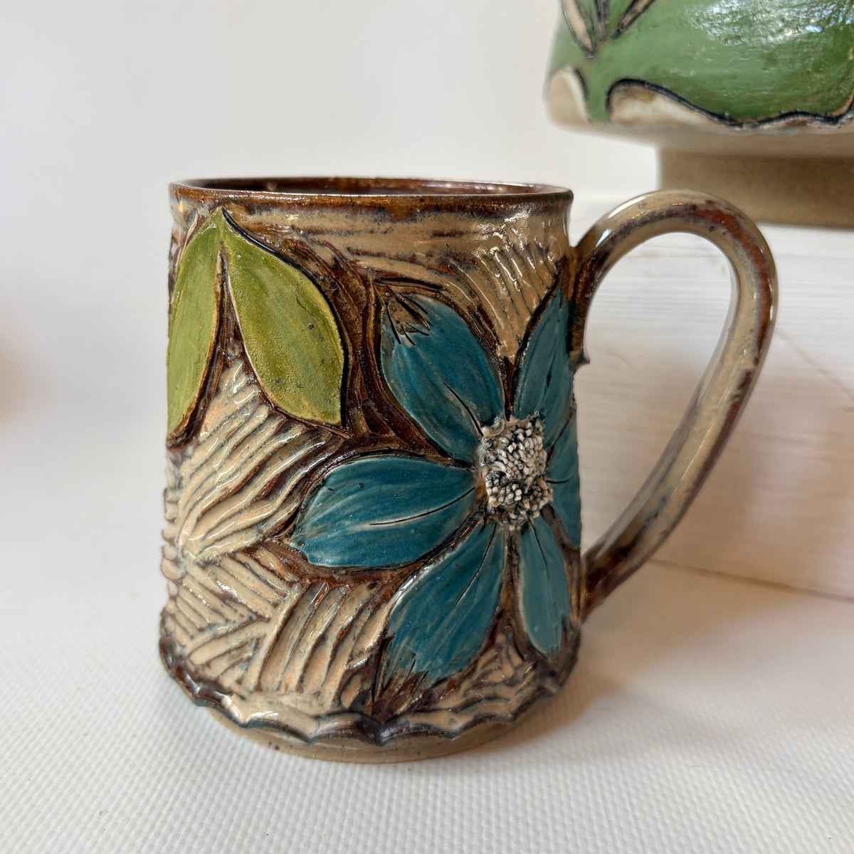 Hand-carved textured mug with floral accent