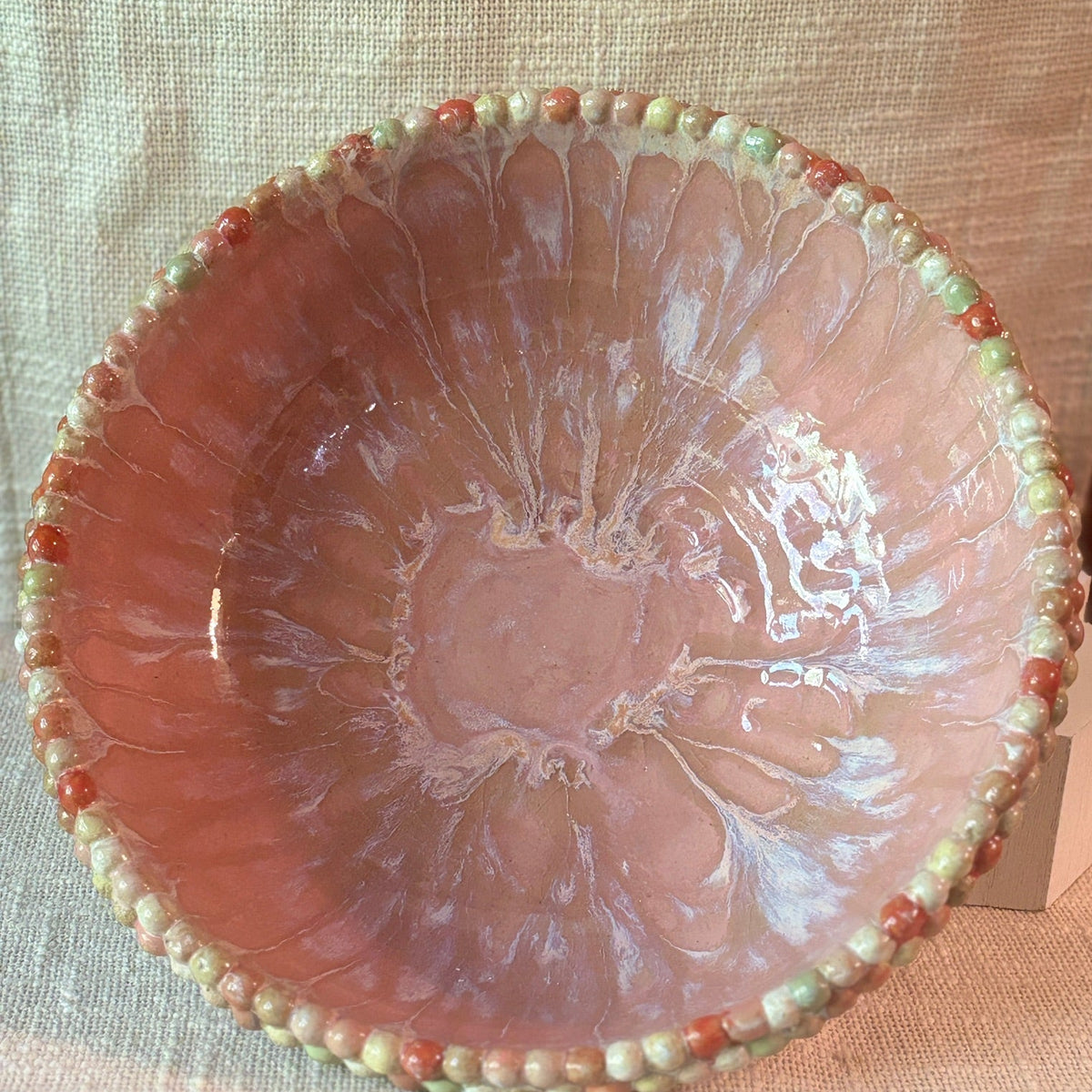 Pink wheel-thrown bowl with a hand-beaded double rim