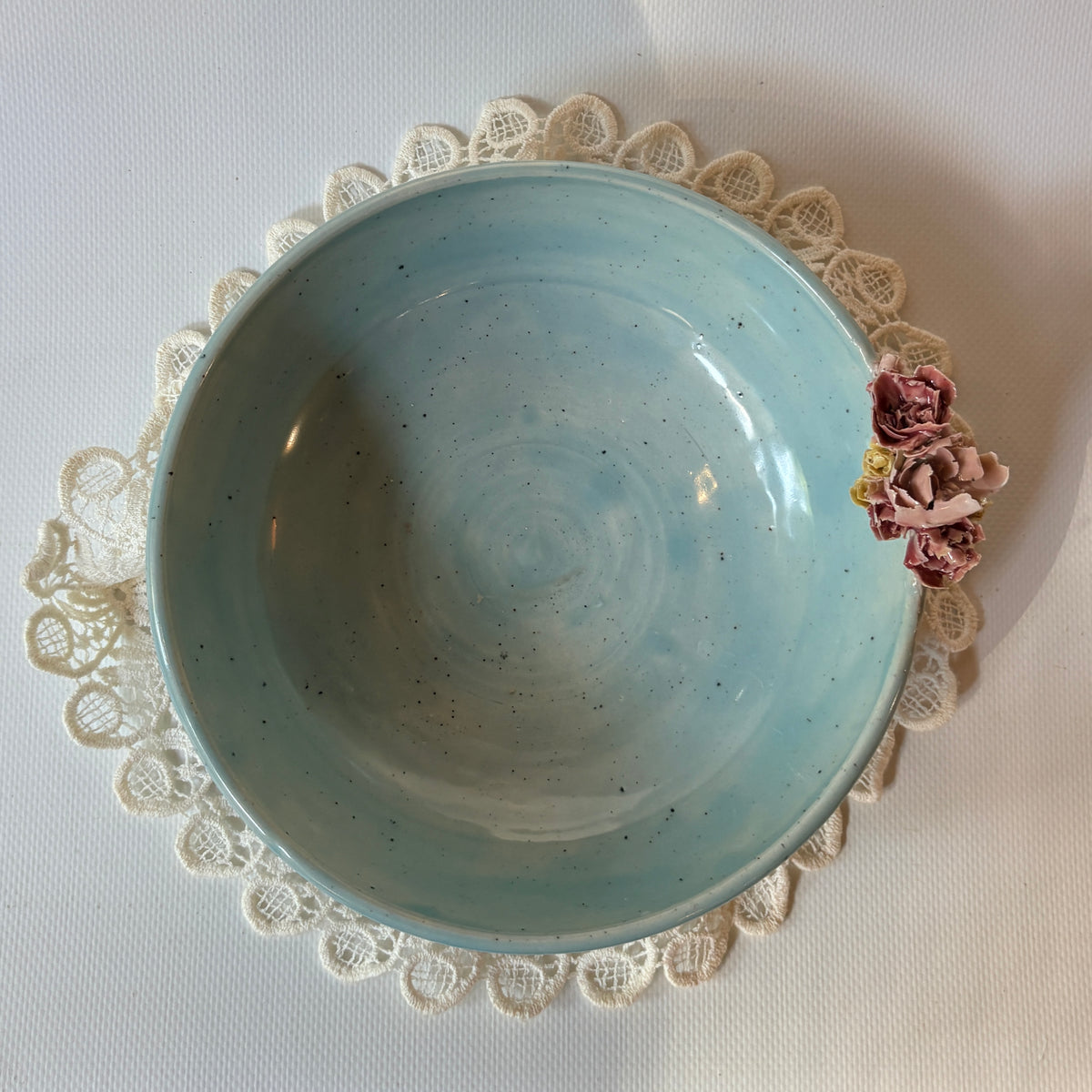 Blue celadon bowl with hand-built floral accent on the rim