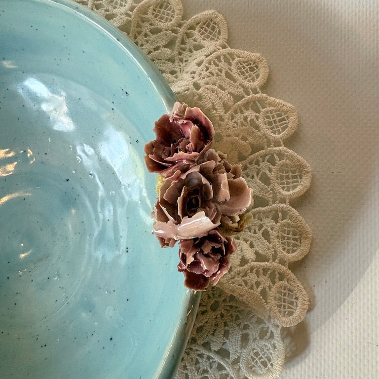 Close up of floral accent on blue celadon bowl