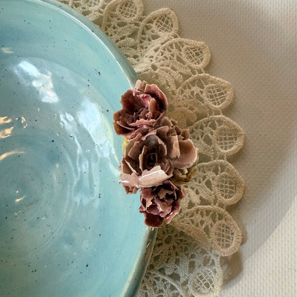 Close up of floral accent on blue celadon bowl